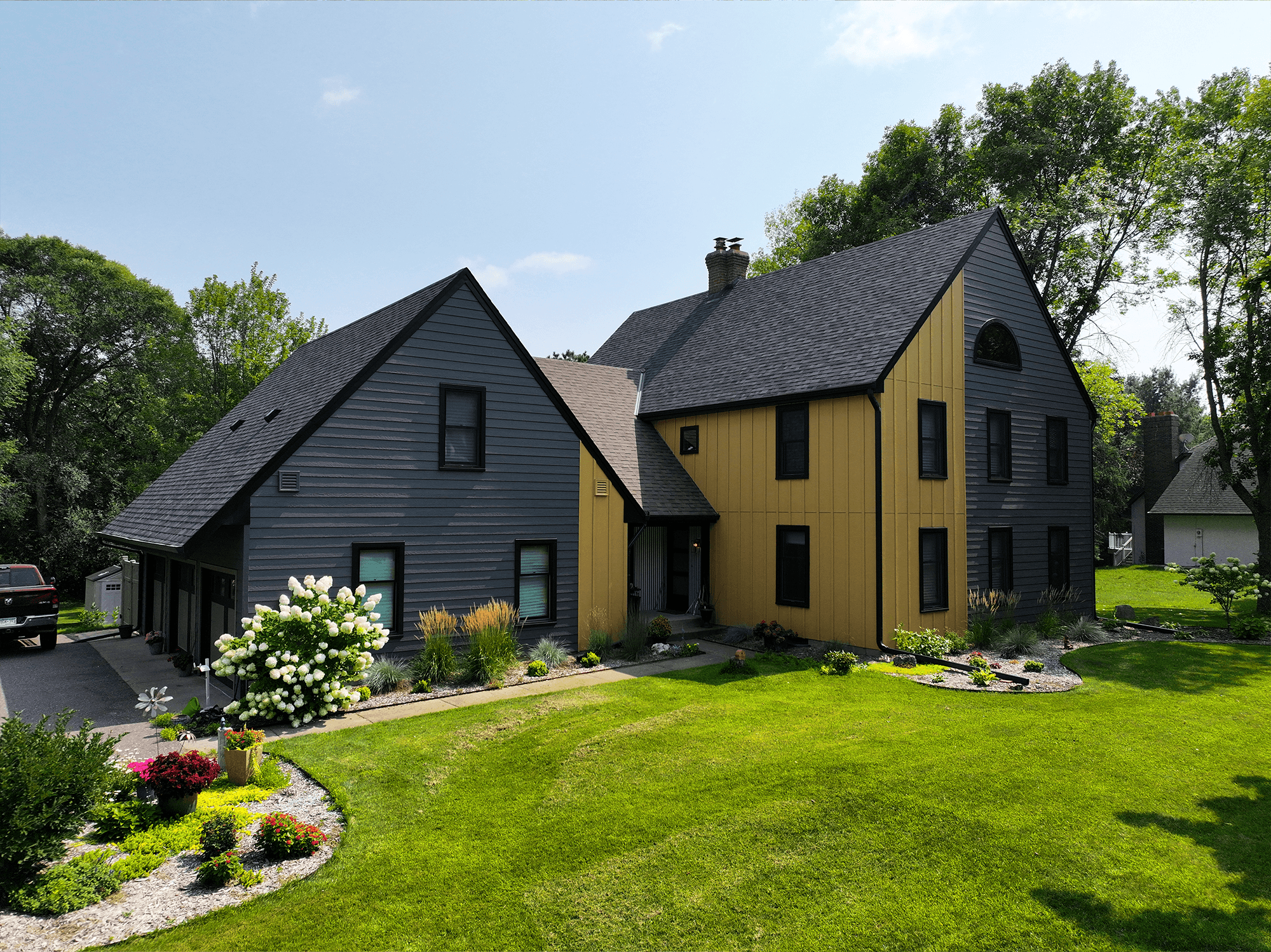 Charcoal lap siding and yellow vertical siding on a house exterior