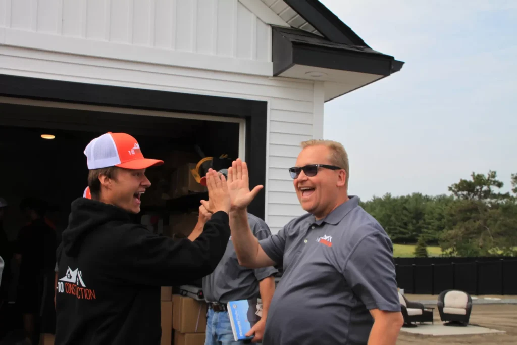 T-10 Construction crew and customers celebrating a completed roofing project